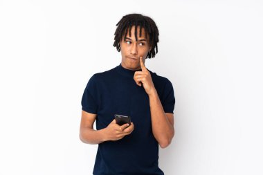 Genç Afrikalı Amerikalı bir adam beyaz arka planda izole edilmiş düşünüyor ve bir mesaj gönderiyor.
