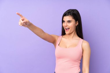 İzole edilmiş mor arka planı olan genç bir kadın.