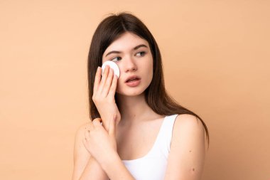 Genç Ukraynalı genç kız, makyajını silmek için pamuk yastıkla izole edilmiş.