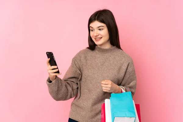 Junge Ukrainische Teenager Mädchen Über Isoliertem Rosa Hintergrund Mit Einkaufstüten — Stockfoto