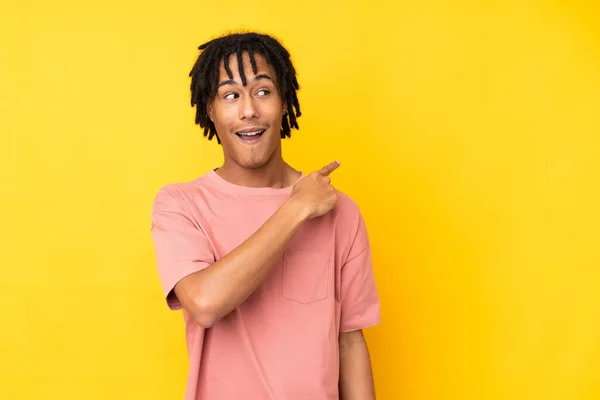 Young African American Man Isolated Yellow Background Surprised Pointing Side — Stock Photo, Image