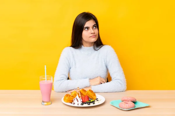 Mujer Joven Comiendo Gofres Batido Una Mesa Sobre Fondo Amarillo —  Fotos de Stock