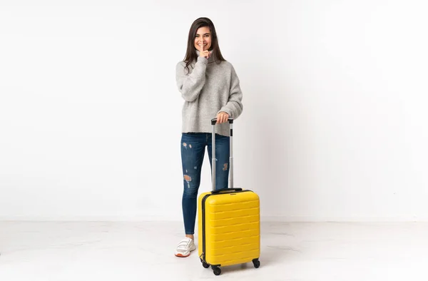 Stock image A full length body of a traveler woman with a suitcase over isolated white wall doing silence gesture