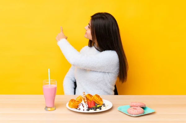 Mujer Joven Comiendo Gofres Batido Una Mesa Sobre Fondo Amarillo —  Fotos de Stock