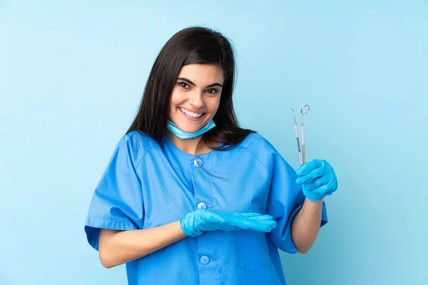 Mujer Joven Dentista Sosteniendo Herramientas Sobre Fondo Azul Aislado Extendiendo —  Fotos de Stock