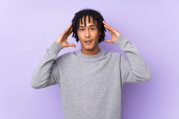 若いアフリカ系アメリカ人男性が紫の背景に驚きの表情で隔離され — ストック写真