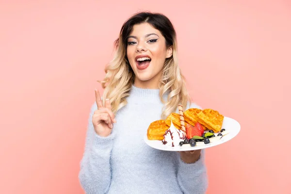 Tiener Meisje Houden Wafels Geïsoleerde Roze Achtergrond Wijzend Een Geweldig — Stockfoto