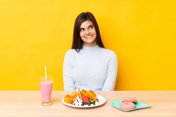 Mujer Joven Comiendo Gofres Batido Una Mesa Sobre Fondo Amarillo —  Fotos de Stock