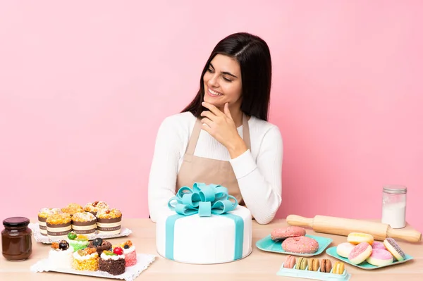 Konditor Mit Einem Großen Kuchen Einem Tisch Über Isoliertem Rosa — Stockfoto