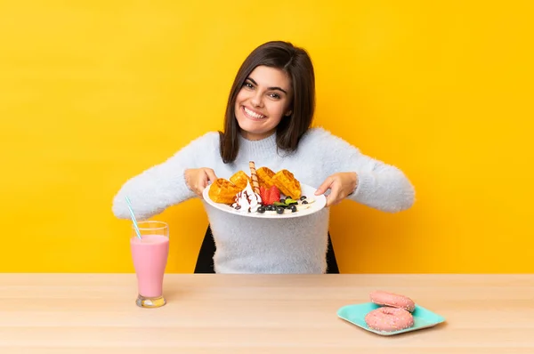 Mujer Joven Comiendo Gofres Batido Una Mesa Sobre Fondo Amarillo —  Fotos de Stock