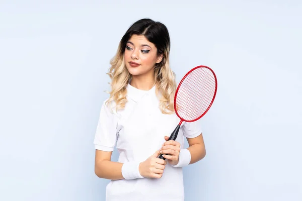 Tonårstjej Spelar Badminton Isolerad Blå Bakgrund Stående Och Tittar Sidan — Stockfoto