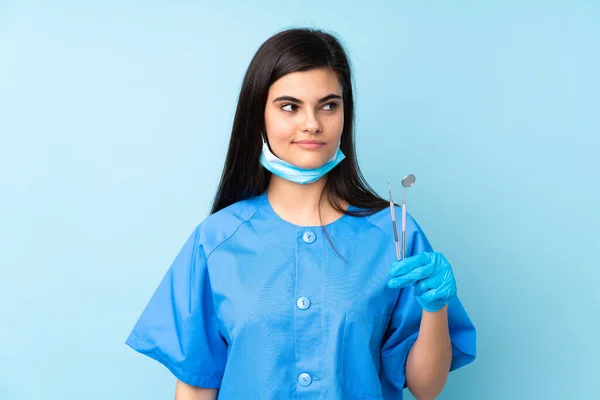 Jeune Femme Dentiste Tenant Des Outils Sur Fond Bleu Isolé — Photo