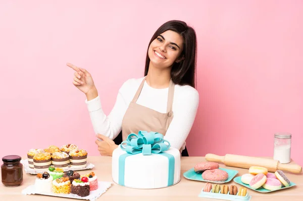 Konditor Mit Einem Großen Kuchen Einem Tisch Über Isoliertem Rosa — Stockfoto