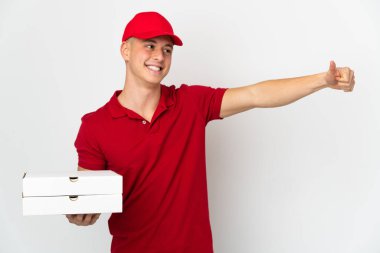 İş üniformalı bir pizzacı beyaz arka planda izole edilmiş pizza kutularını topluyor.