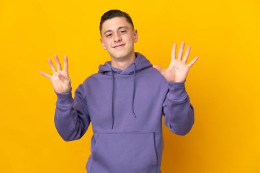 Sarı arka planda izole edilmiş beyaz bir adam dokuz parmaklı sayıyor.