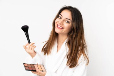 Beyaz arka planda makyajlı ve mutlu beyaz bir kadın.