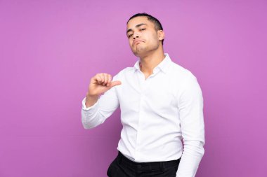 Asyalı yakışıklı adam mavi arka planda kendini beğenmiş ve gururlu.