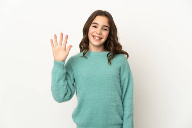 Beyaz arka planda izole edilmiş küçük beyaz kız mutlu bir ifadeyle selamlıyor.