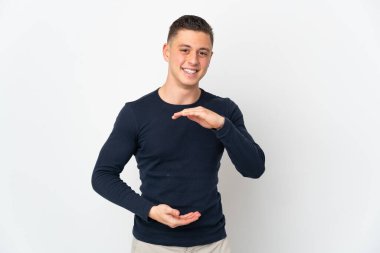 Beyaz arka planda izole edilmiş genç beyaz bir adam bir ilan vermek için avucunun içinde hayali bir fotokopi makinesi tutuyor.