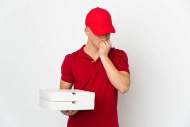 İş üniformalı bir pizzacı beyaz arka planda izole edilmiş pizza kutularını alıyor.