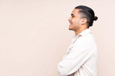 Asyalı yakışıklı adam izole edilmiş arka planda yan pozisyonda.