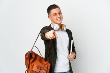 Beyaz arka planda izole edilmiş beyaz tenli genç bir öğrenci, mutlu bir ifadeyle öne bakıyor.