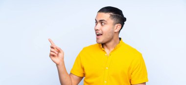 Asyalı yakışıklı adam, izole edilmiş arka planda parmağını kaldırarak çözümü bulmaya çalışıyor.