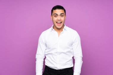 Asyalı yakışıklı adam mavi arka planda izole edilmiş, şaşırmış bir yüz ifadesi var.