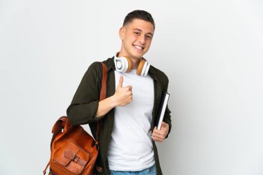 Beyaz arka planda izole edilmiş beyaz tenli genç bir öğrenci baş parmak işareti yapıyor.