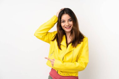 Beyaz arka planda izole edilmiş genç beyaz kadın şaşırmış ve işaret ediyor.