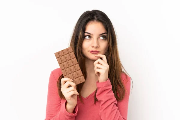Fiatal Kaukázusi Elszigetelt Rózsaszín Alapon Vesz Egy Csokoládé Tabletta Kétségei — Stock Fotó