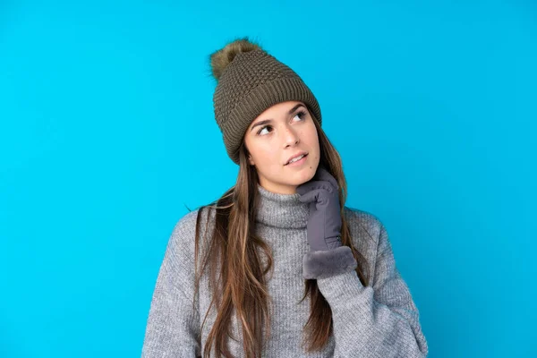 Menina Adolescente Com Chapéu Inverno Sobre Fundo Azul Isolado Pensando — Fotografia de Stock