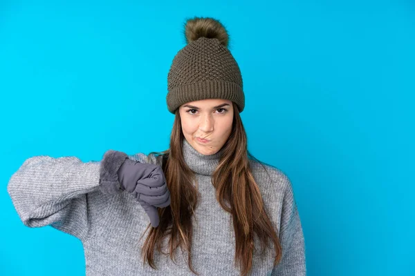 Teenager Κορίτσι Χειμερινό Καπέλο Πάνω Από Απομονωμένο Μπλε Φόντο Δείχνει — Φωτογραφία Αρχείου