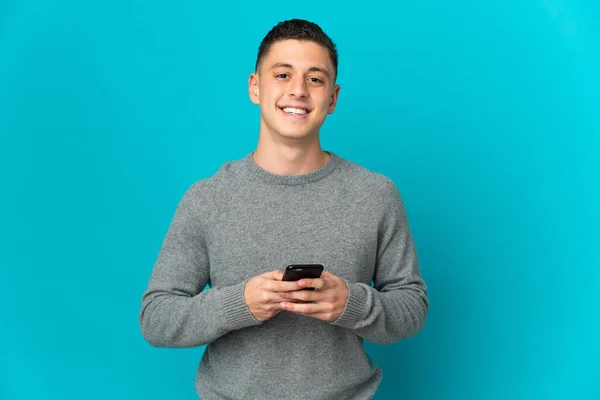 Joven Hombre Caucásico Aislado Sobre Fondo Azul Mirando Cámara Sonriendo —  Fotos de Stock