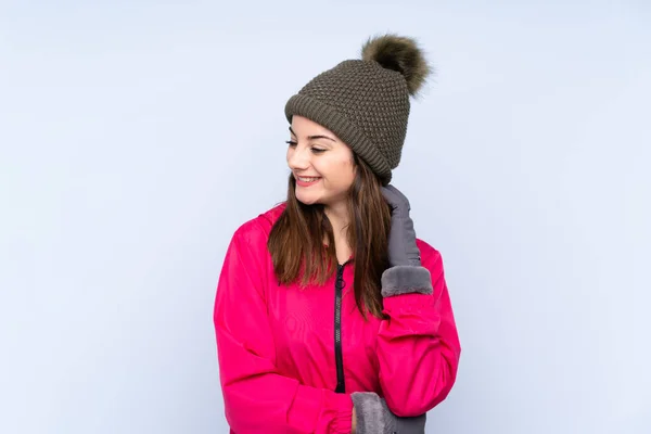 年轻姑娘戴着冬帽 背景是蓝色的 她想出了一个主意 — 图库照片