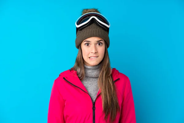 ティーンスキーヤー女の子とともにスノーボードメガネ上の隔離された青の背景に疑問を持っていますとと混同顔の式 — ストック写真