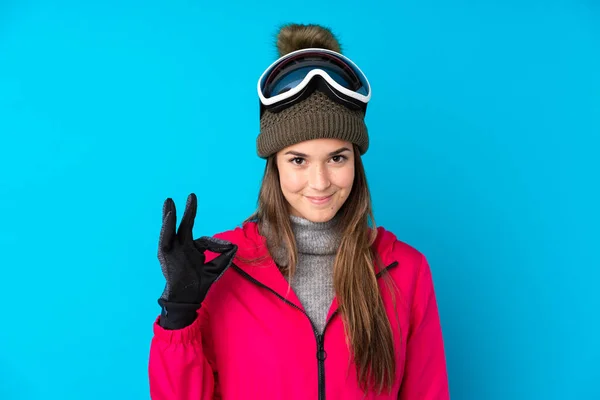 Nastoletnia Narciarka Okularach Snowboardowych Odizolowanym Niebieskim Tle Pokazującym Znak Palcami — Zdjęcie stockowe