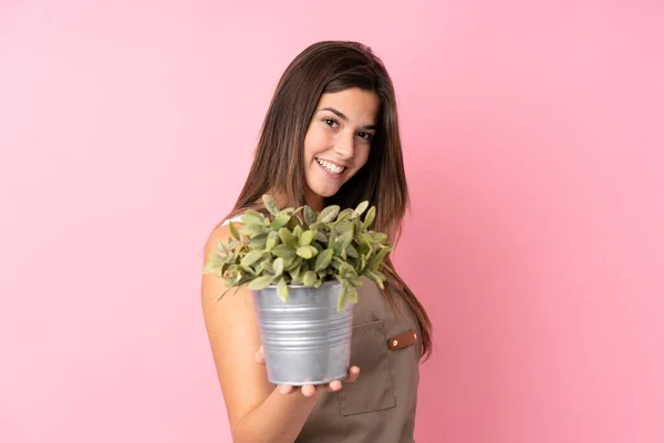 Tini Kertész Lány Gazdaság Egy Növény Felett Elszigetelt Rózsaszín Háttér — Stock Fotó