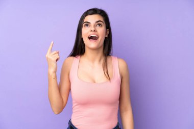 İzole edilmiş, mor arka planı olan genç bir kadın.