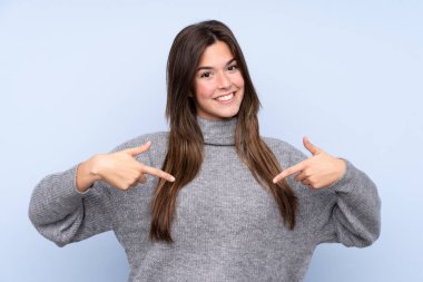 Genç Brezilyalı kız soyutlanmış mavi arka plan gururlu ve kendini beğenmiş.