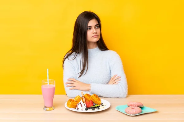 Mujer Joven Comiendo Gofres Batido Una Mesa Sobre Fondo Amarillo —  Fotos de Stock