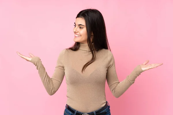 Mujer Joven Sobre Fondo Rosa Aislado Sosteniendo Copyspace Con Dos —  Fotos de Stock