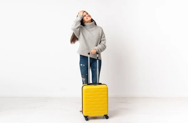 白い壁の上にスーツケースを持つ旅行者の女性の完全な長さの体笑って — ストック写真