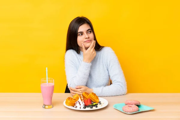 Mujer Joven Comiendo Gofres Batido Una Mesa Sobre Fondo Amarillo —  Fotos de Stock