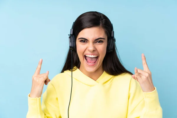 Mujer Joven Sobre Fondo Azul Aislado Escuchando Música Haciendo Gesto —  Fotos de Stock