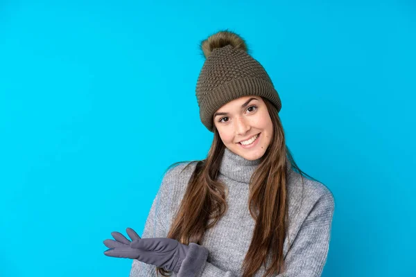 一个戴着冬帽 身披深蓝色背景的少女向旁边伸出手来 邀请她来 — 图库照片