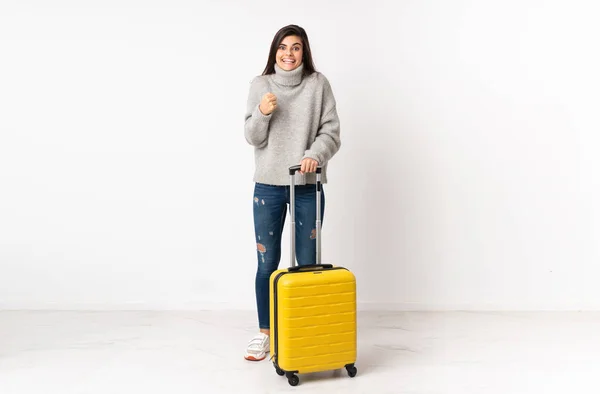 全身上下都是一个带着手提箱的女旅行家 她带着手提箱穿过孤零零的白墙庆祝胜利 — 图库照片