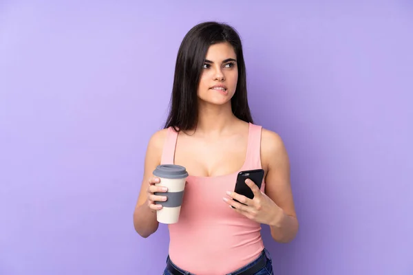 Giovane Donna Sfondo Viola Isolato Che Tiene Caffè Portare Cellulare — Foto Stock