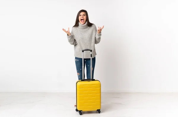 白い壁の上にスーツケースを持つ旅行者の女性の完全な長さの体不幸なと何かに不満 — ストック写真