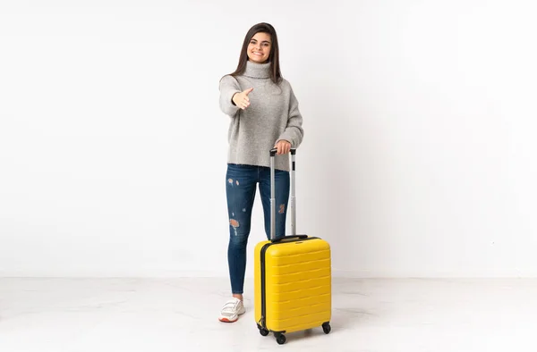スーツケースを持つ旅行者の女性の完全な長さボディ隔離された白い壁の上に握手後に良い取引 — ストック写真